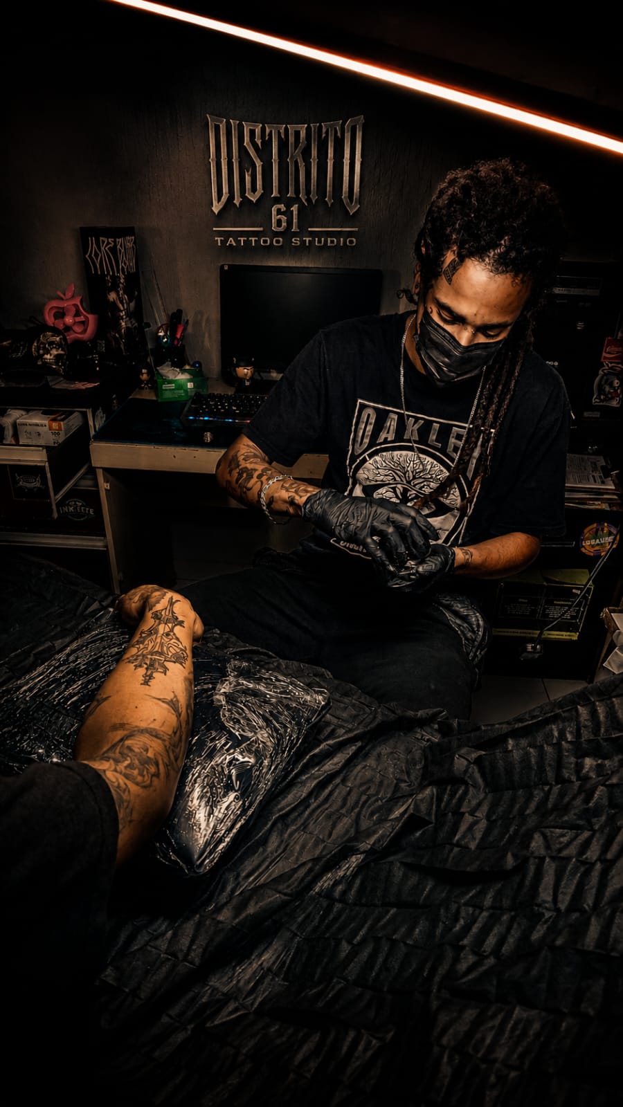 Tatuador do Distrito 61 trabalhando no estúdio